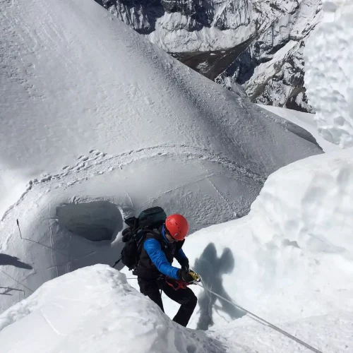 Mountaineer climbing Island Peak snow ridge during mountaineering training UK expedition