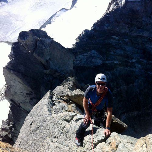 MCI instructor on mountain ridge. UK mountaineering training guide