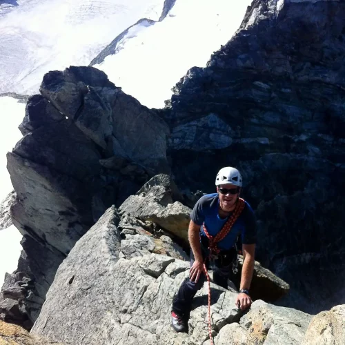 MCI instructor on mountain ridge. UK mountaineering training guide